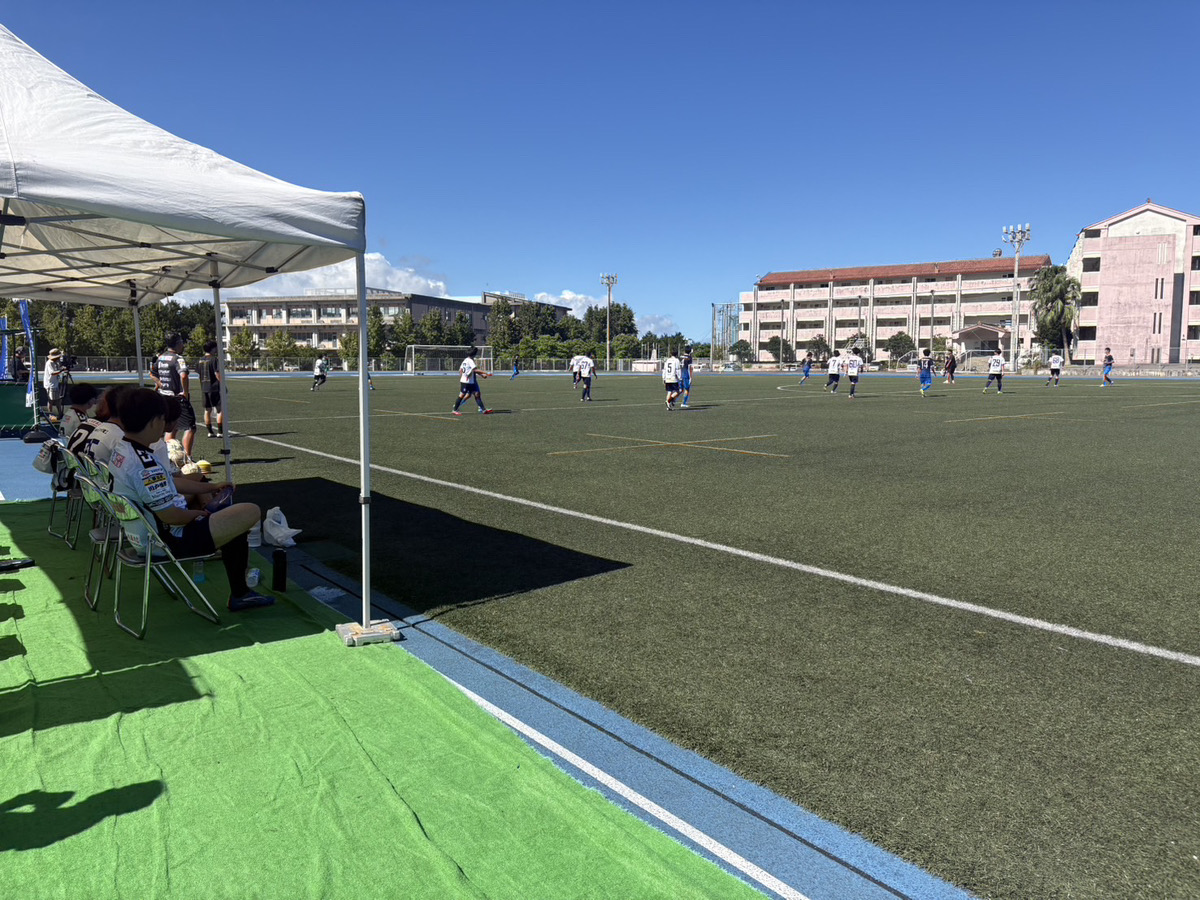 テント下のベンチから試合を見守るチーム関係者