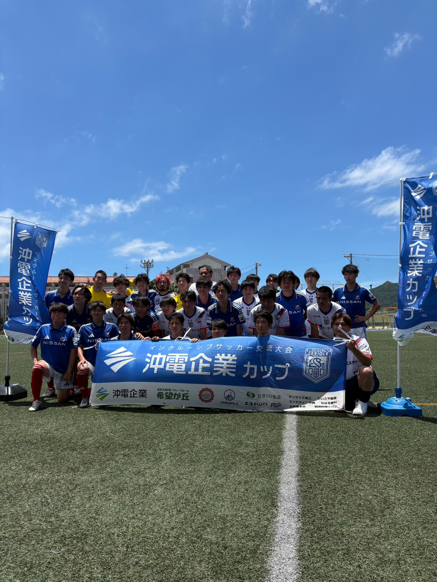 大会の横断幕を囲んで記念撮影する参加チームの選手たち