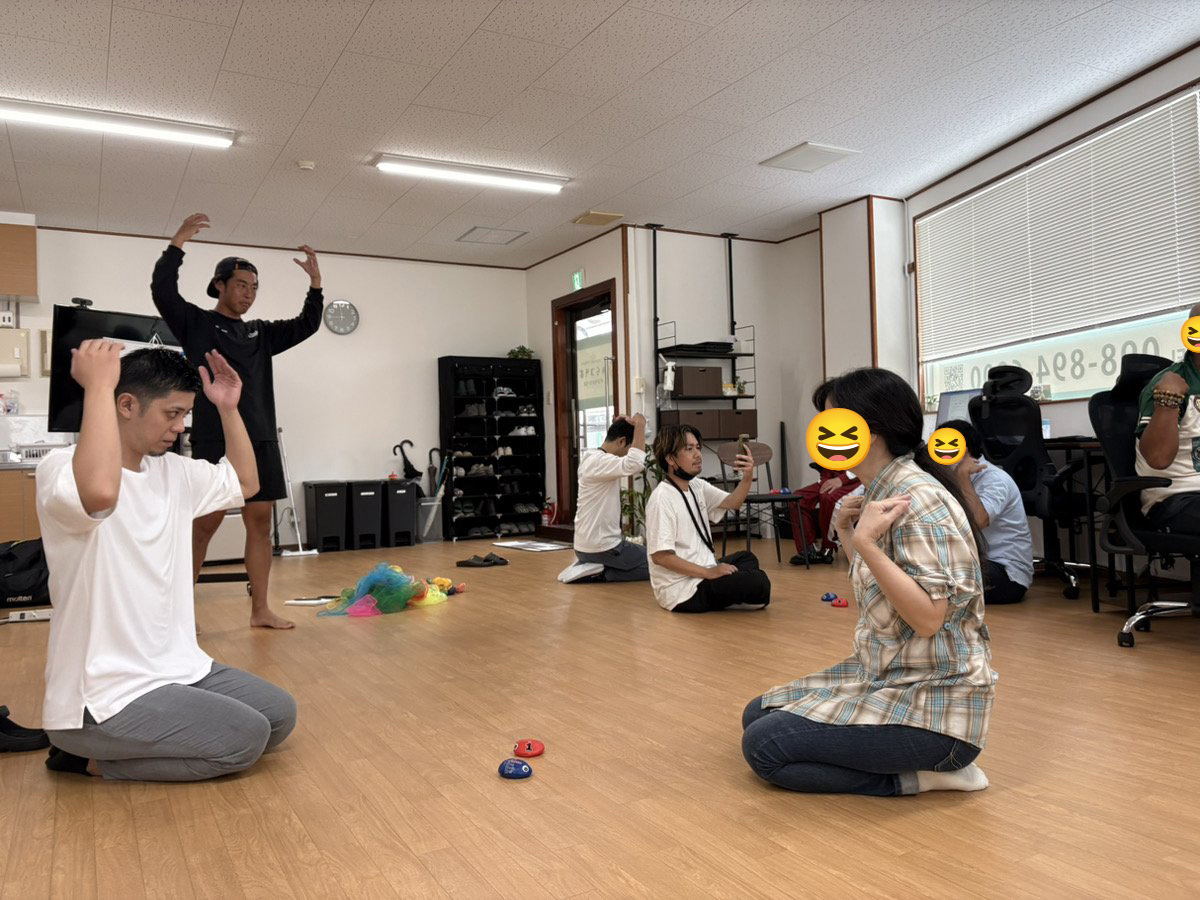 床に座り、左右で違う動きを同時に行うプログラムに挑戦する