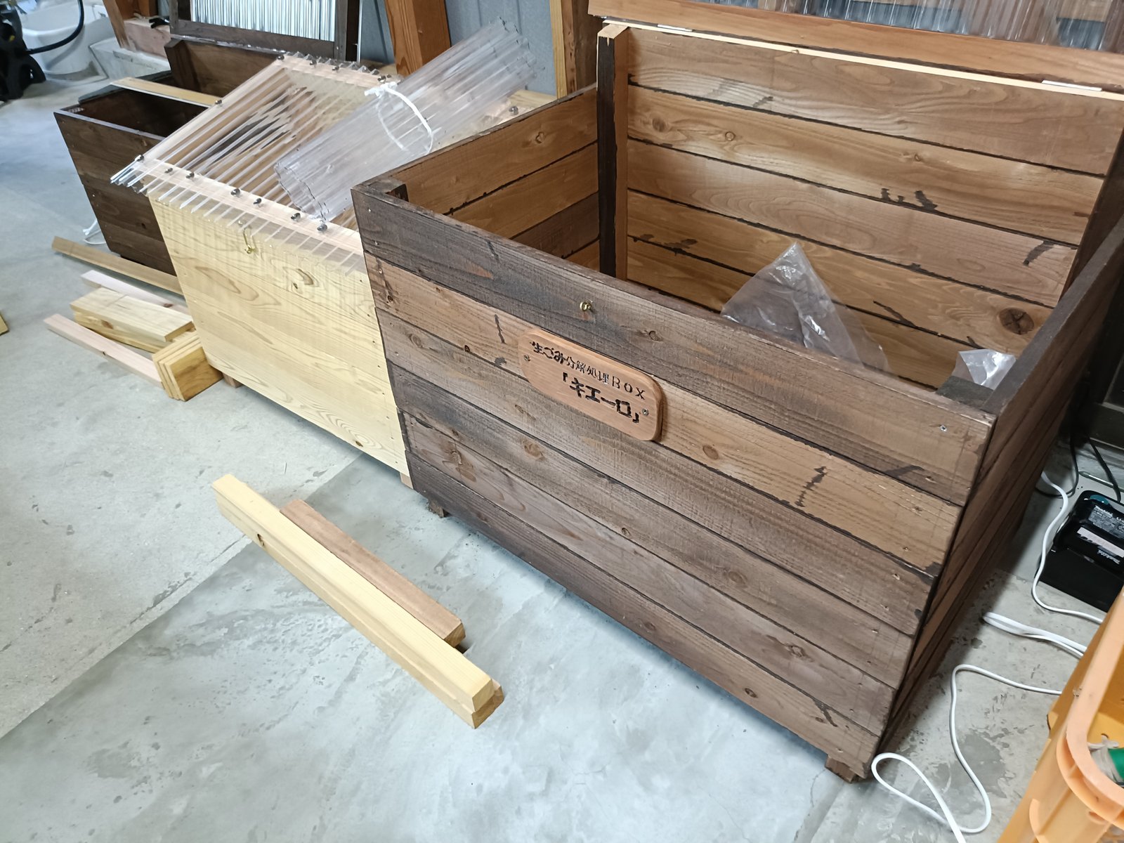 濃い茶色に塗装された見本のキエーロ。前面に「生ごみ分解処理BOX キエーロ」のネームプレート付き
