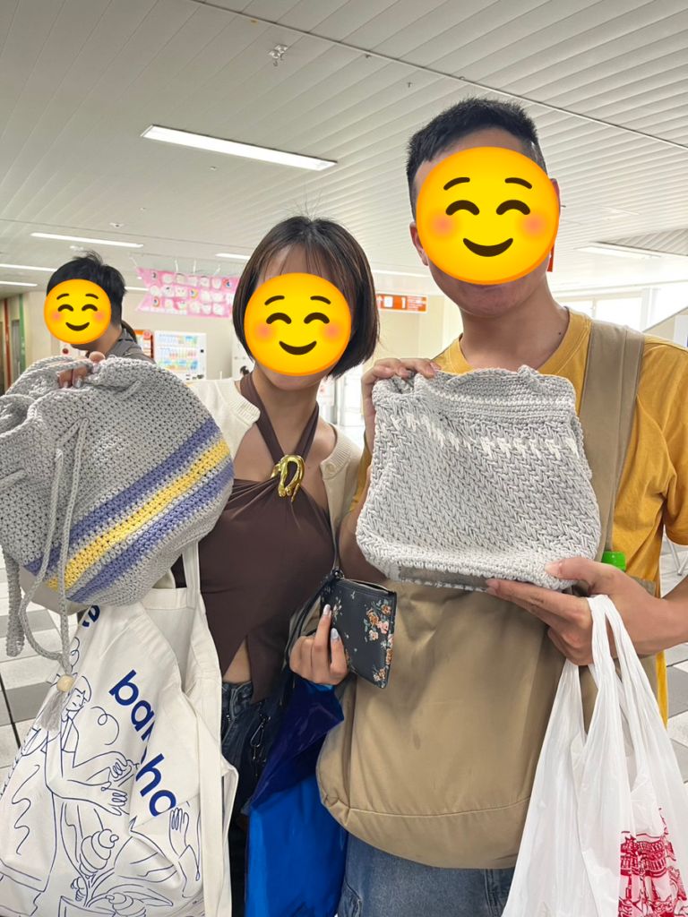 おもろまち駅のマルシェで、利用者さんが手編みしたバッグを手にするお客さま