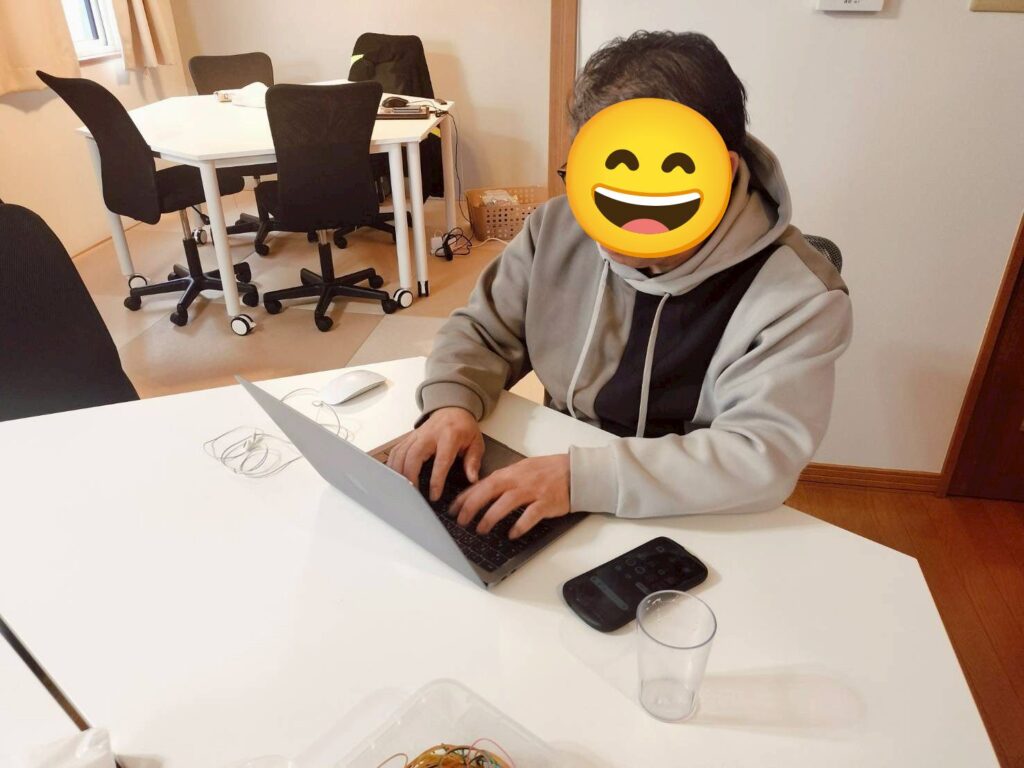 明るい室内で、利用者さんがノートパソコンに向かって作業している様子