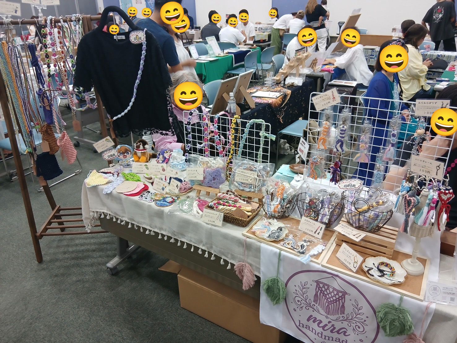 白い布をかけた長机とワイヤーネットに、手作りのストラップやアクセサリー、布小物を並べたみらコラボ浦添経塚のマルシェ出店ブース