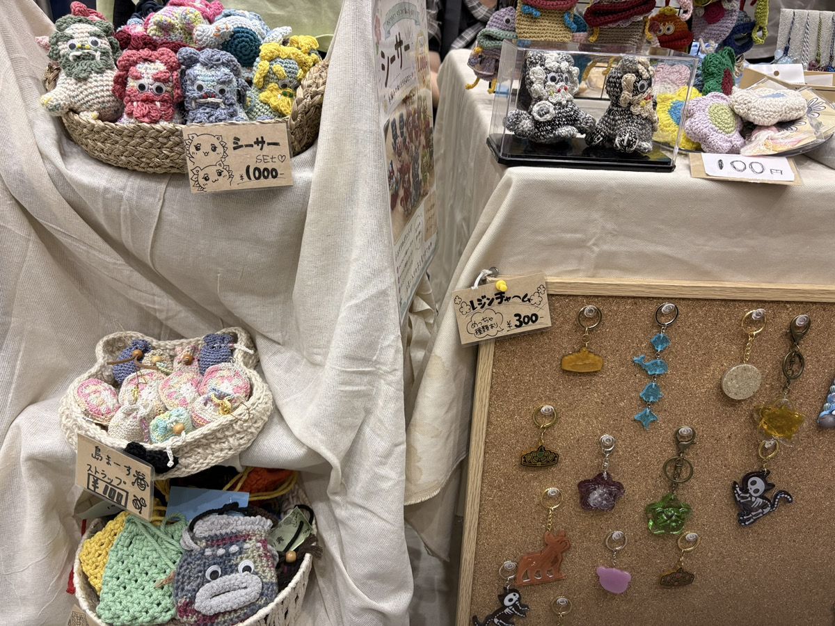かごに入った編みぐるみのシーサーと、コルクボードに並ぶレジンのキーホルダー
